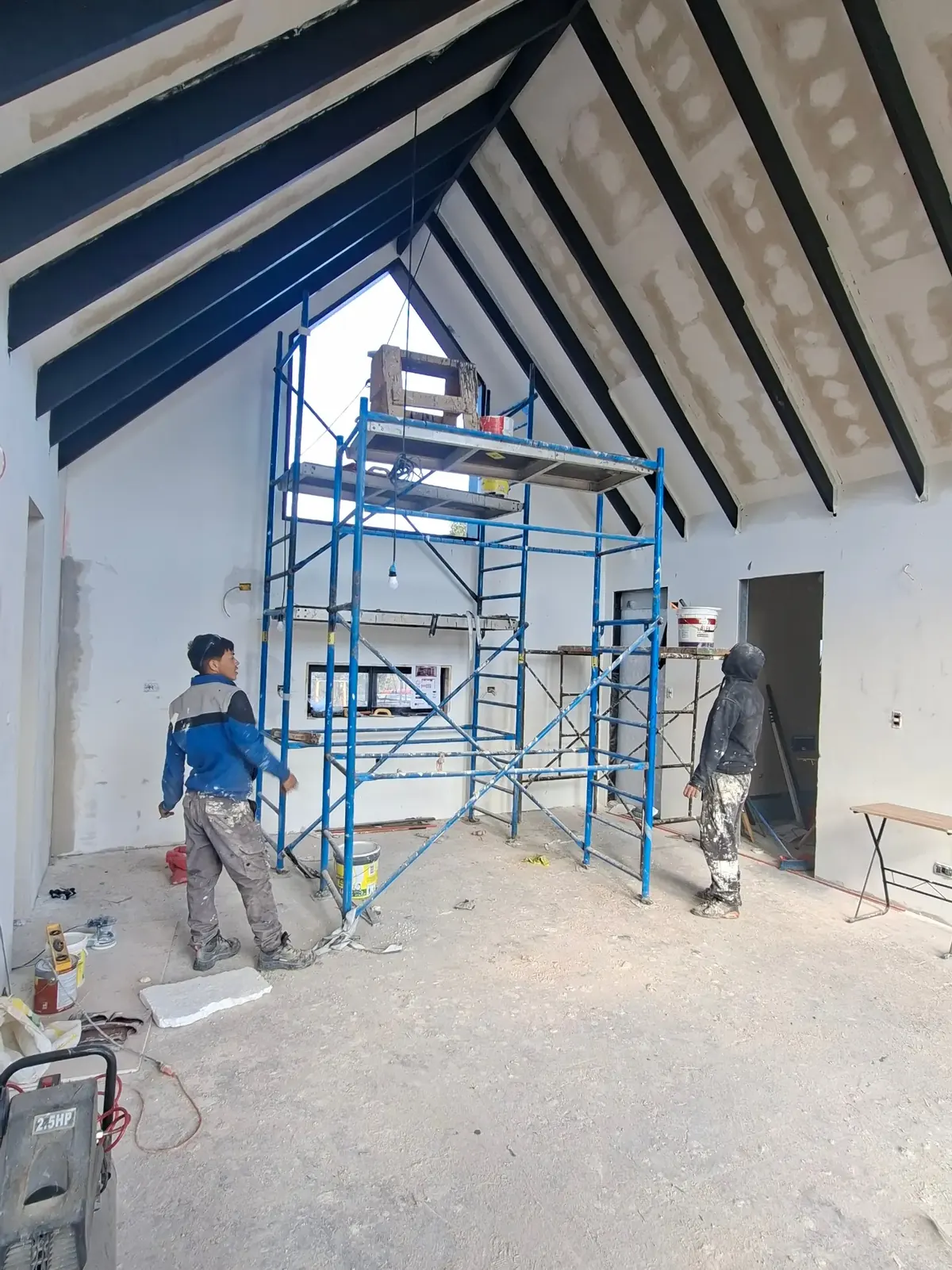 Etapa de pastas y pinturas en Nordic Home, con las vigas pintadas de negro y andamios