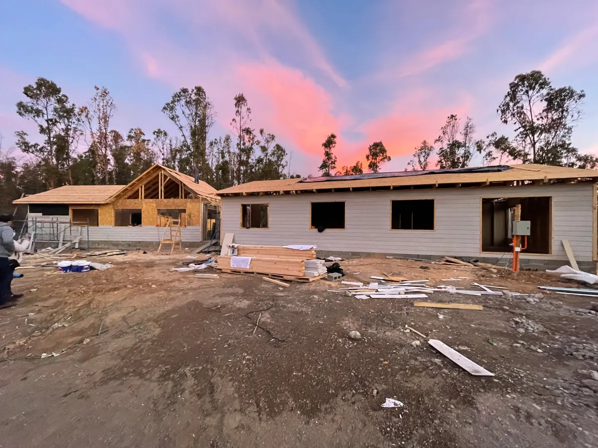 Obra en La Foresta de Zapallar al atardecer, con estructura de techumbre en madera