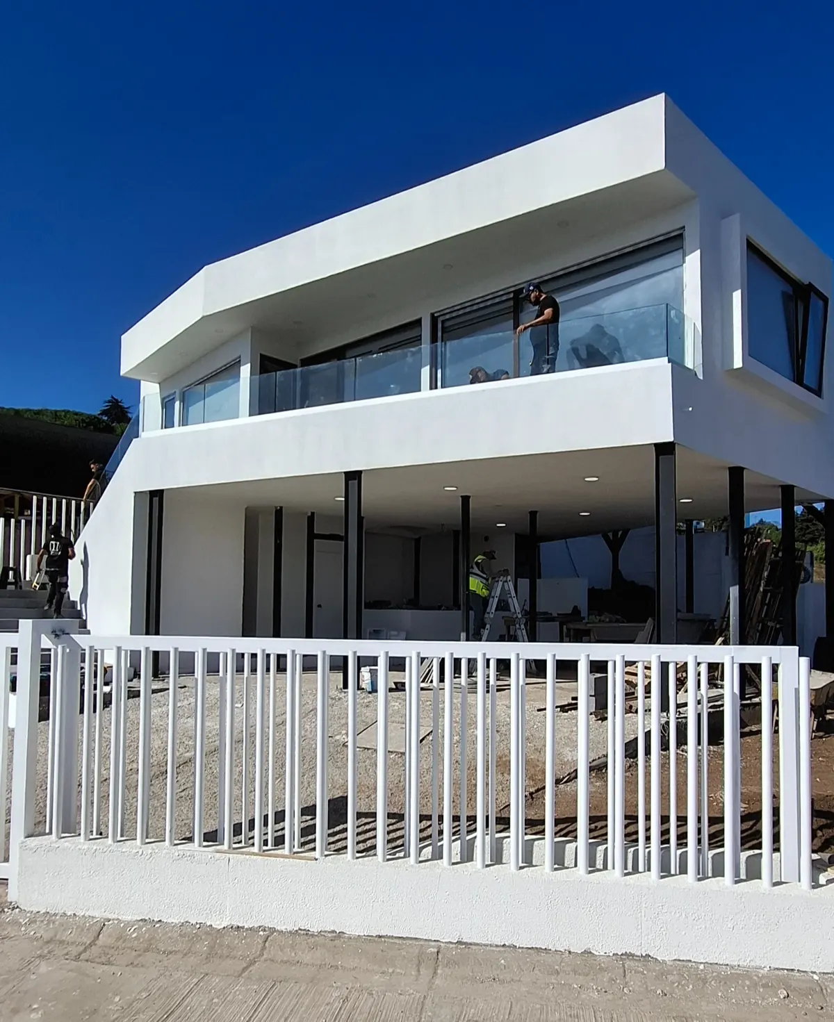 Fachada de Casa Mantagua con balcón vidriado y reja blanca