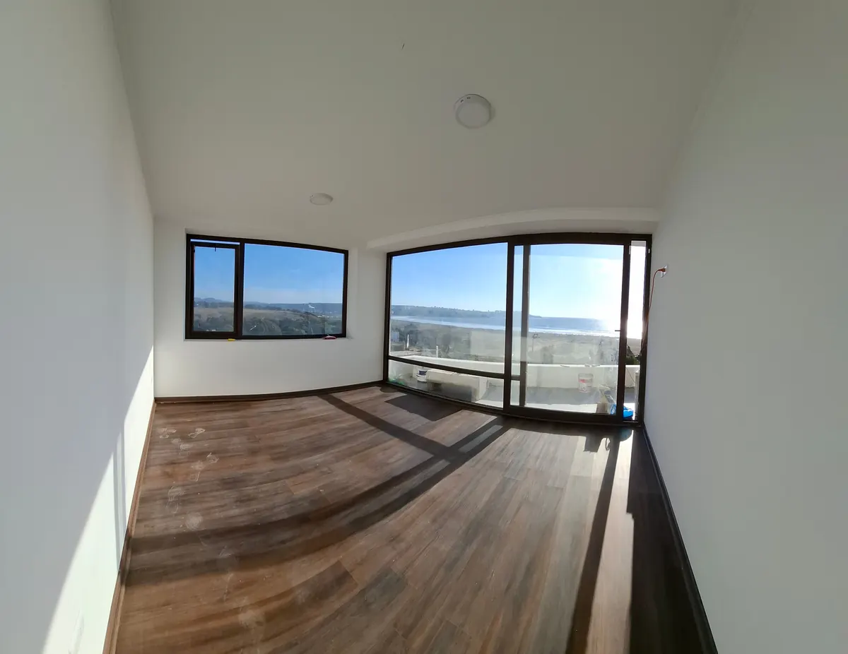 Dormitorio de Casa Mantagua con ventanales hacia el mar y piso SPC