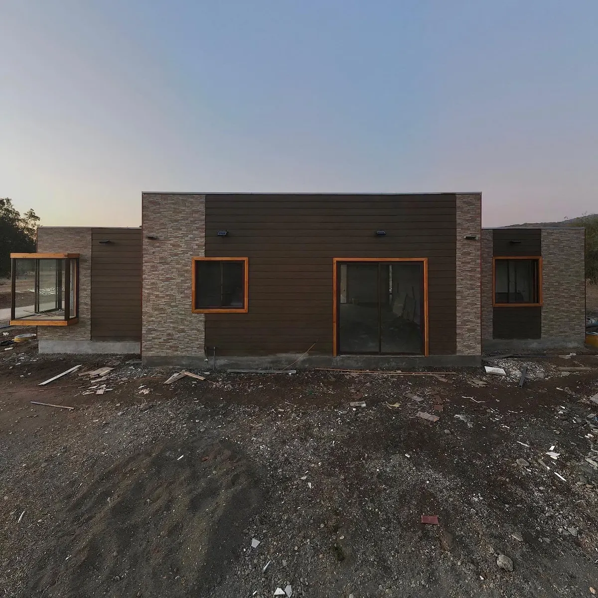 Fachada de Casa Mediterráneo con revestimiento de piedra pizarra y siding de fibrocemento