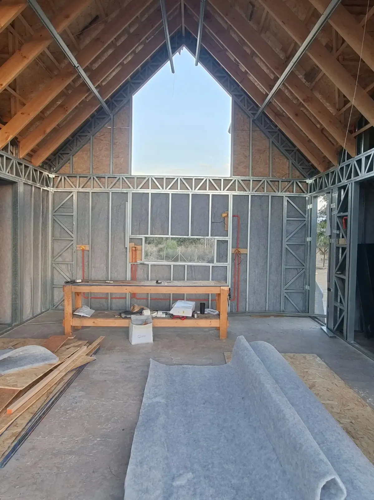 Tabiques de acero con placas de OSB y rollo de aislación en el piso de la obra
