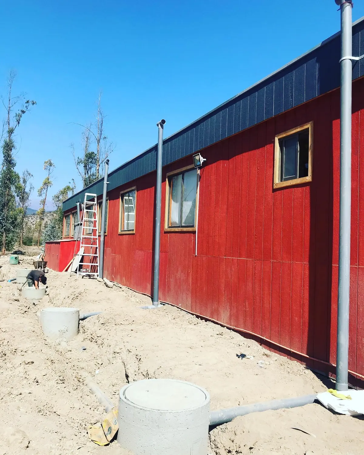 Casa en obra con cámara de inspección y tuberías sanitarias en el terreno