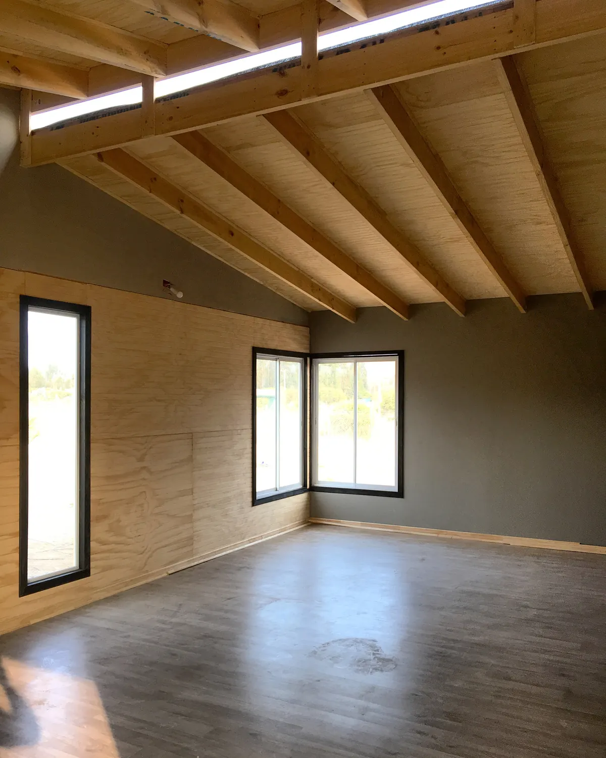 Interior de la Casa V-26 con vigas de madera a la vista y piso flotante